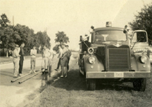 Men stand around an old fire truck