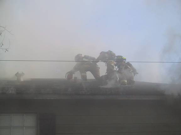 Fire fighters on the roof of the burning apartment