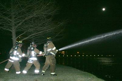 Fire fighters spraying a fire hose
